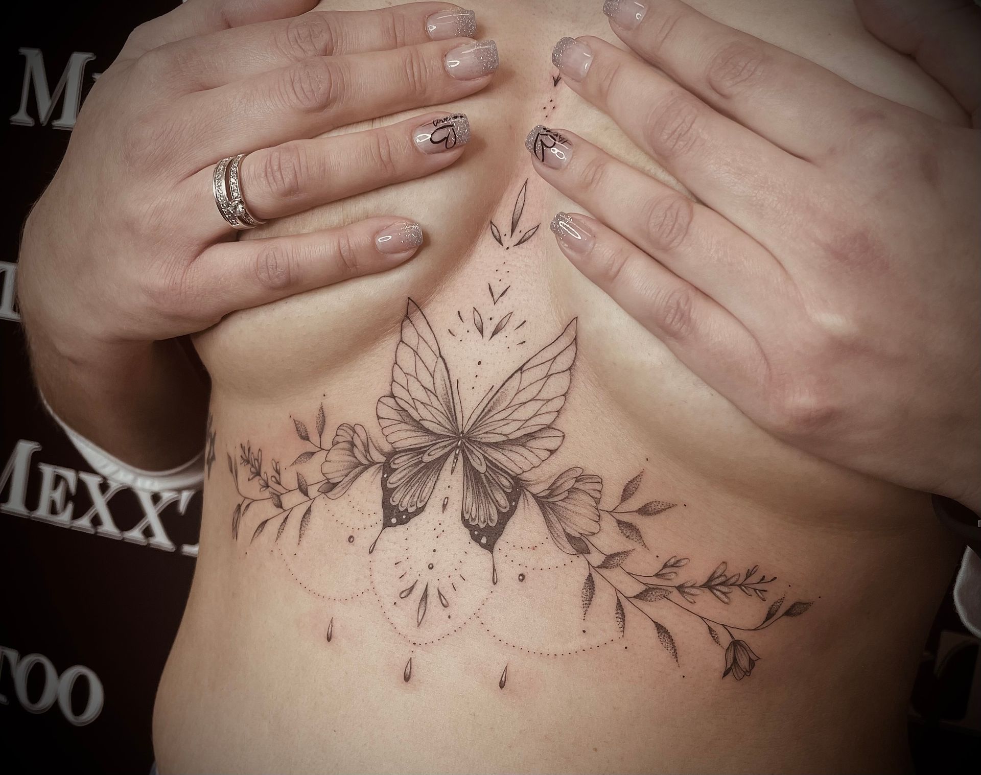 eine Frau mit einem Schmetterling-Tattoo auf ihrer Brust