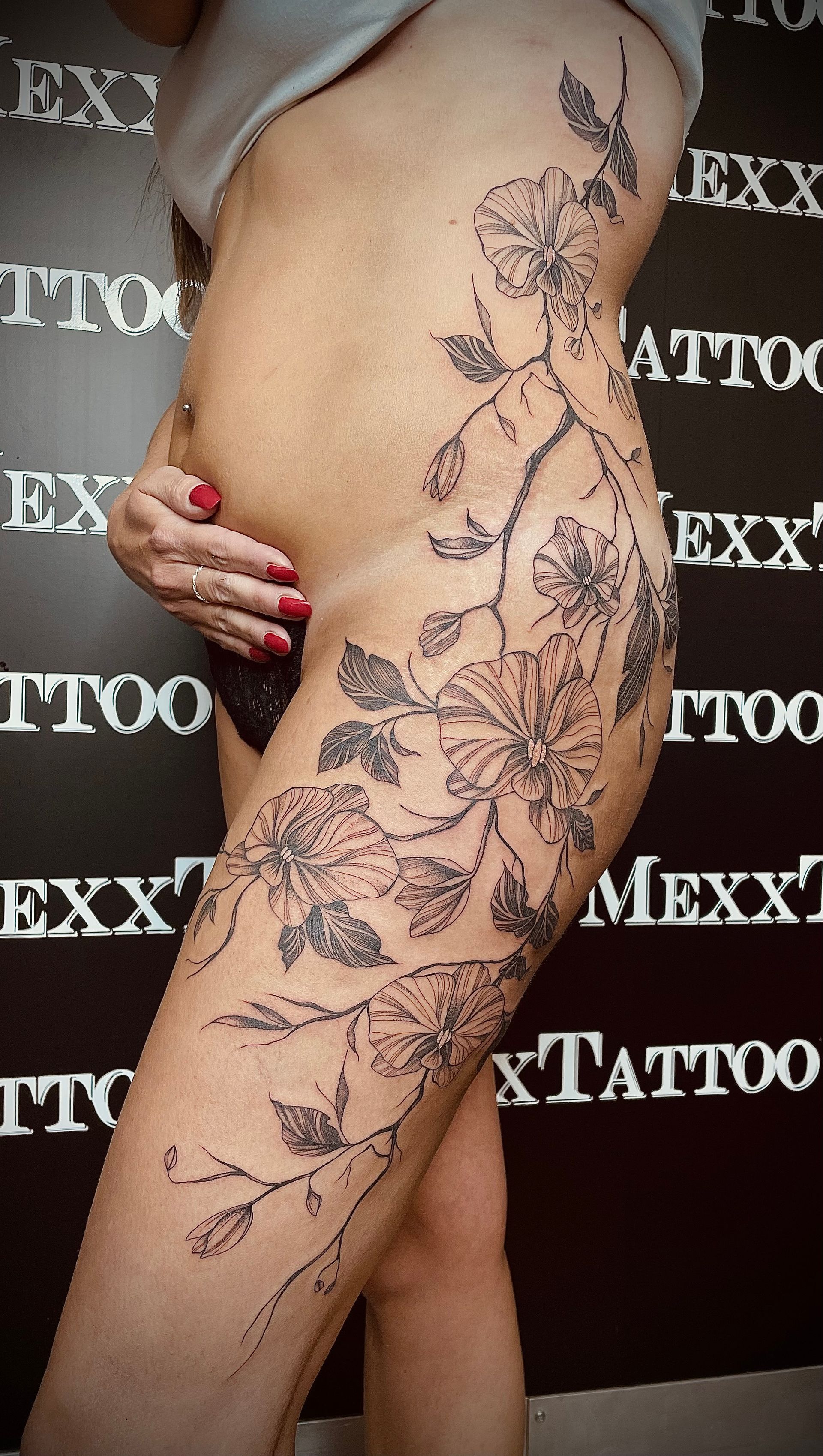 eine Frau mit einem Blumentattoo auf ihrem Bein