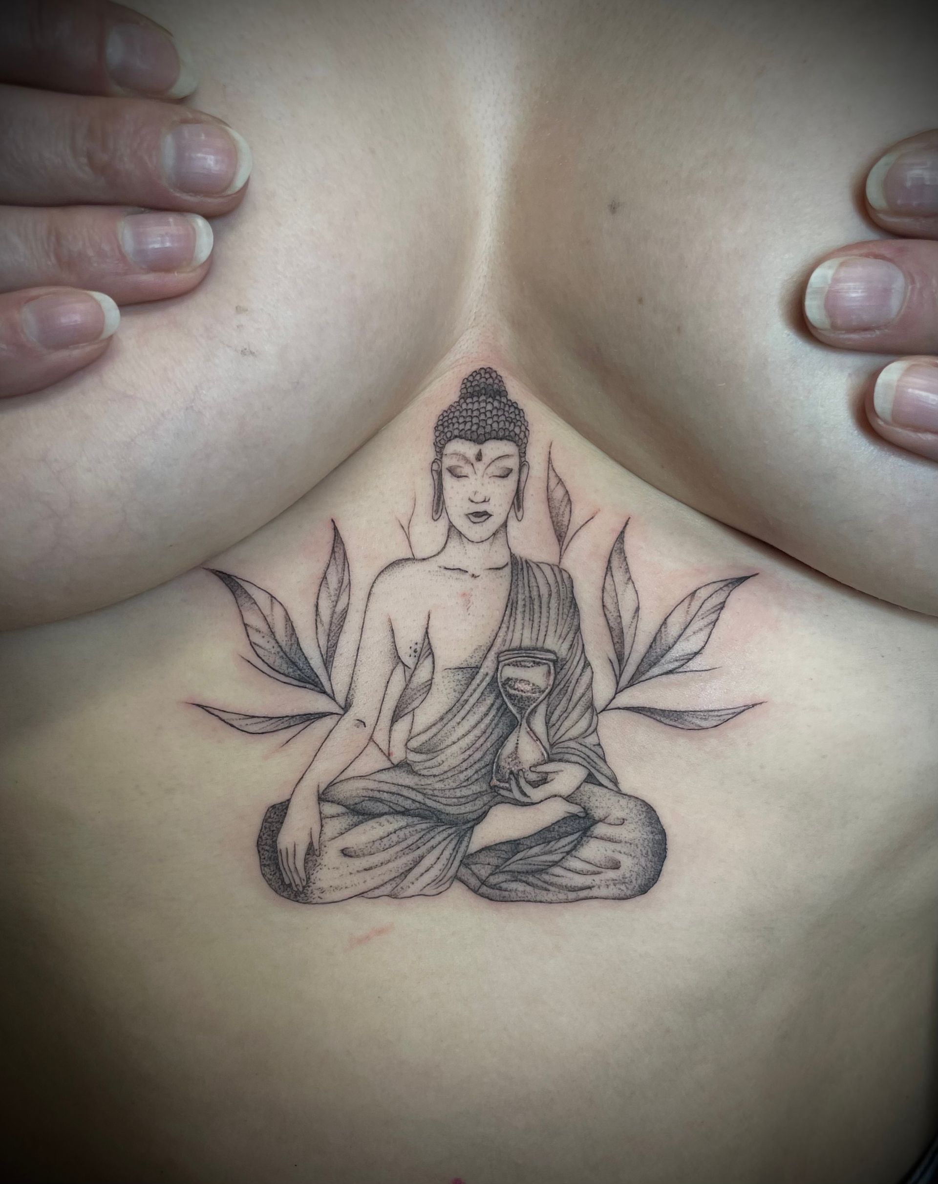eine Frau mit einem buddhistischen Tattoo auf ihrer Brust