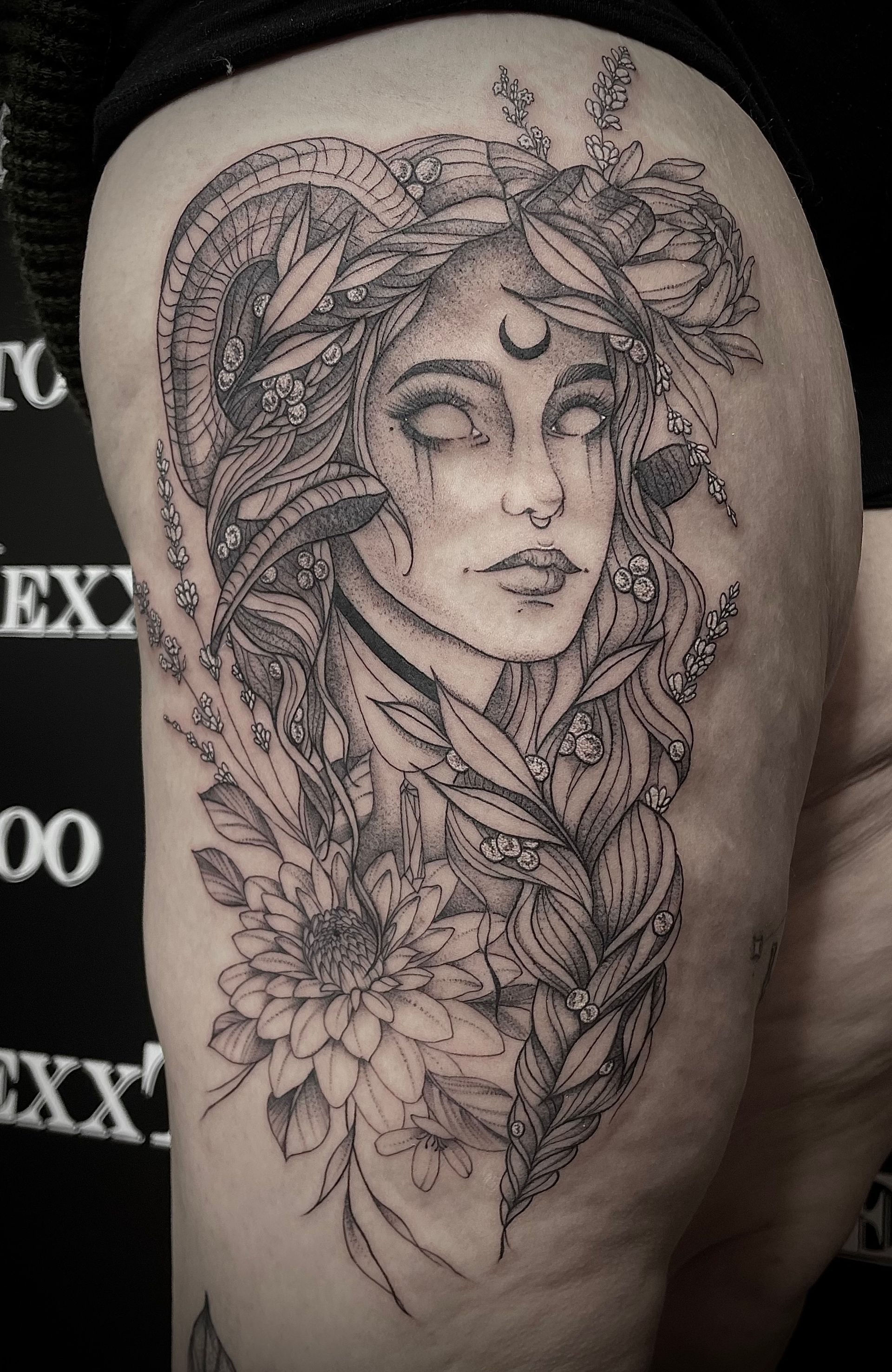 ein Schwarz-Weiß-Tattoo einer Frau auf ihrem Oberschenkel