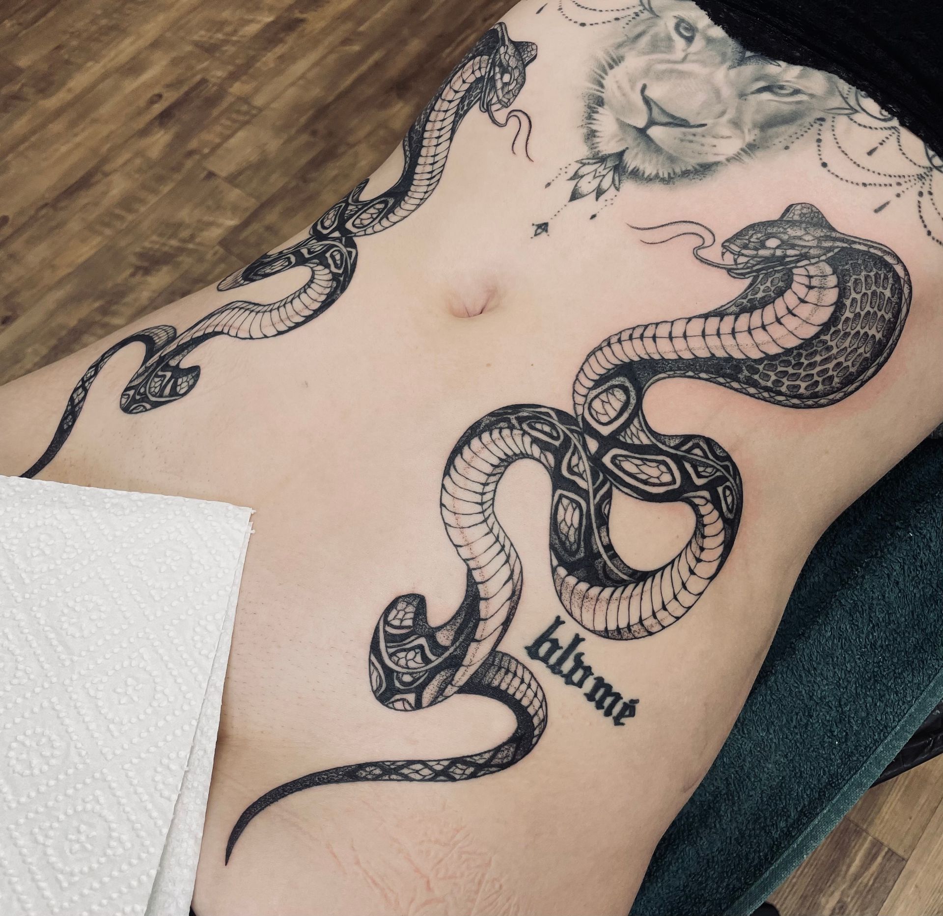 eine Frau mit einem Schlange-Tattoo auf ihrem Bauch