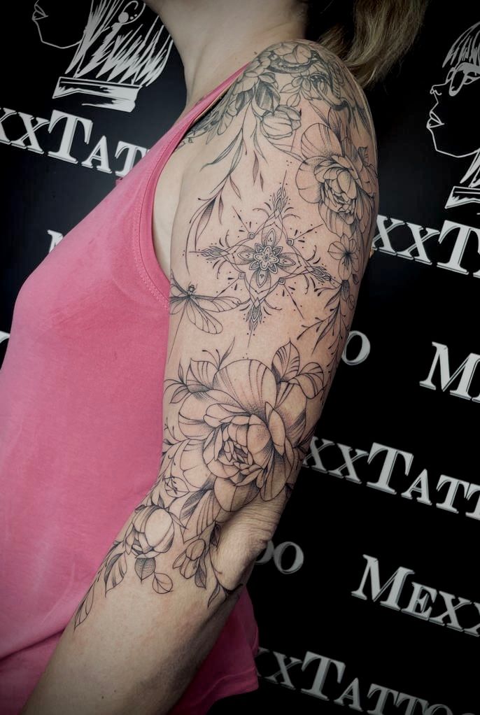 eine Frau mit einem Blumentattoo auf ihrem Arm .