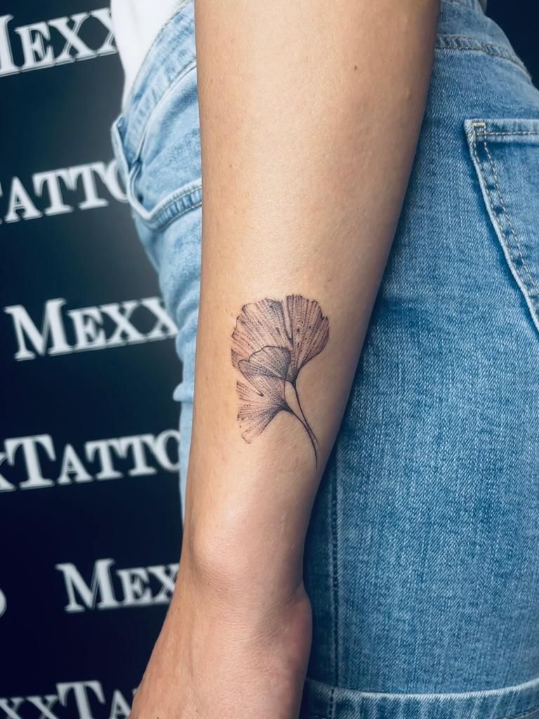 eine Frau mit einem kleinen Tattoo auf ihrem Arm