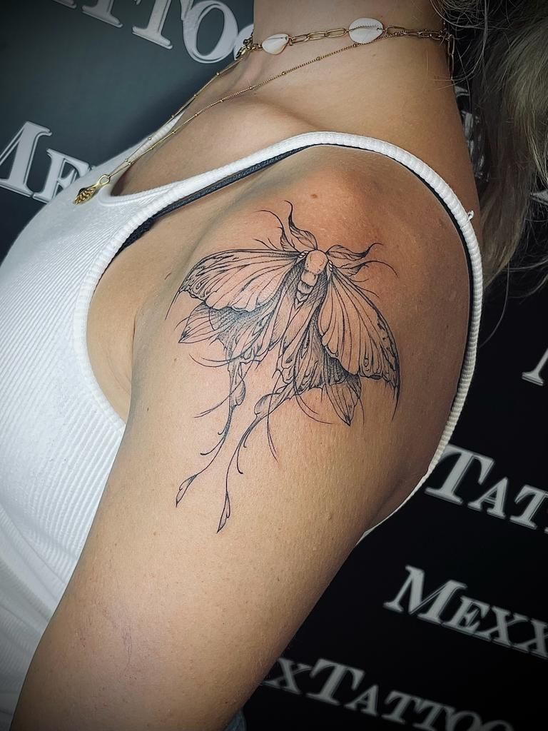eine Frau mit einem Schmetterling-Tattoo auf ihrer Schulter .