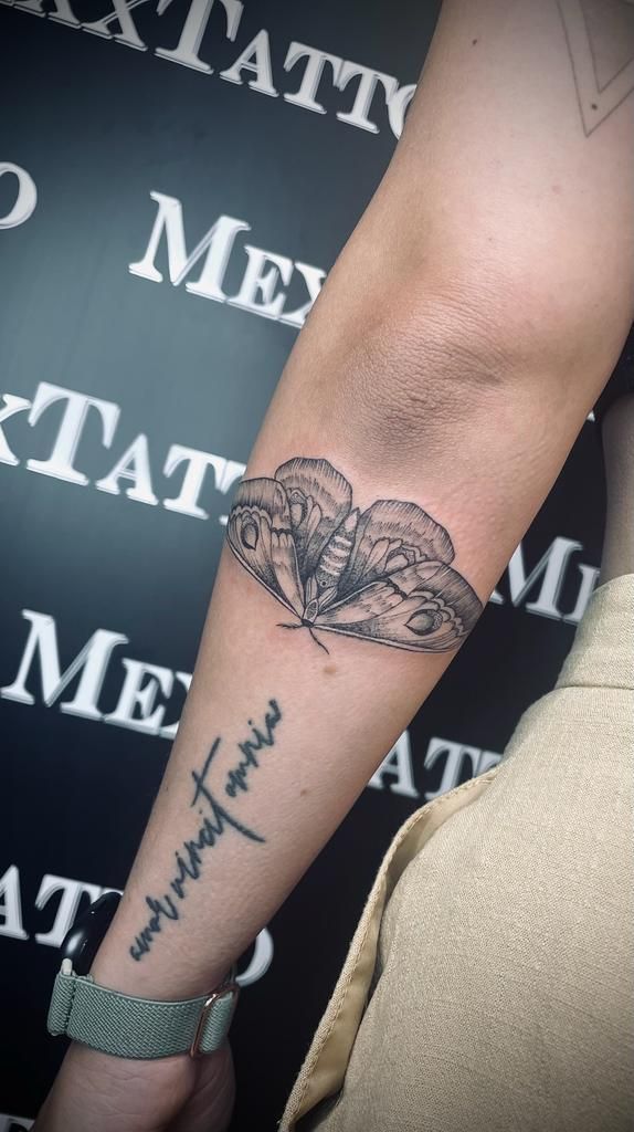 eine Frau mit einem Schmetterling-Tattoo auf ihrem Arm .