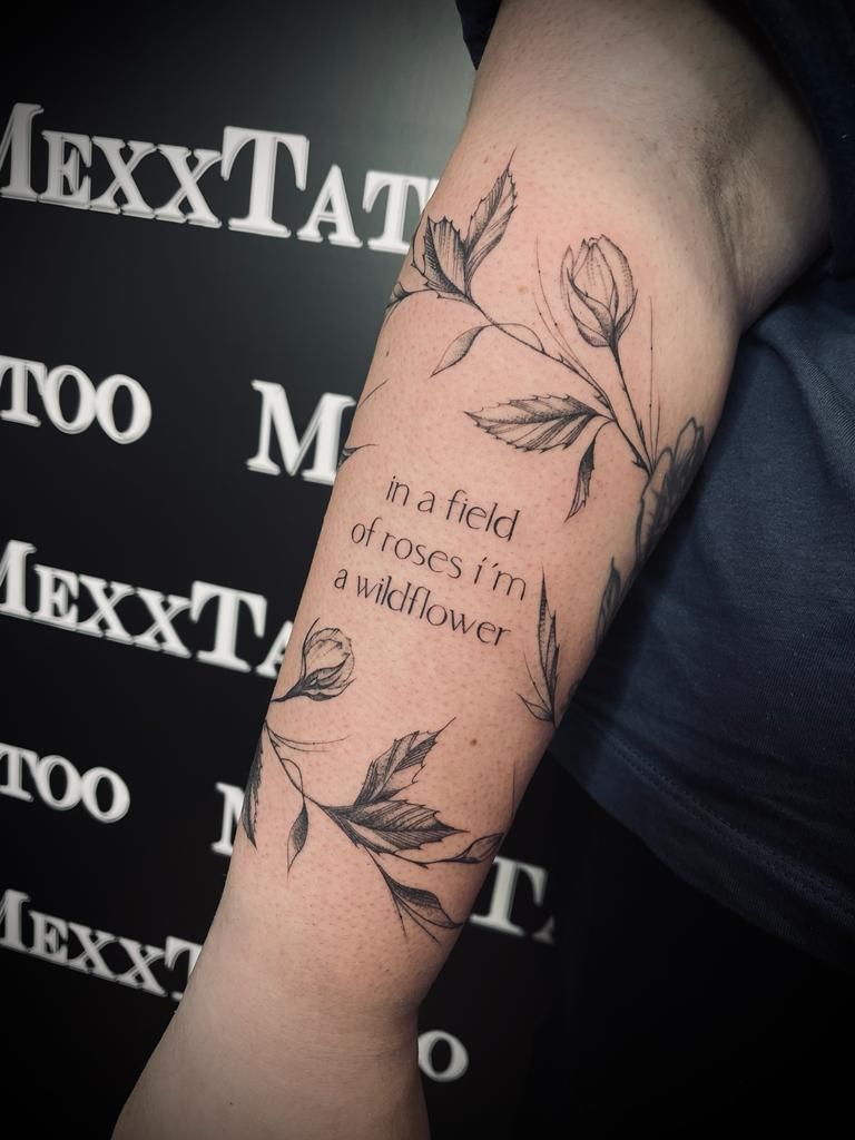 eine Person mit einem Tattoo auf ihrem Arm mit einem Zitat darauf