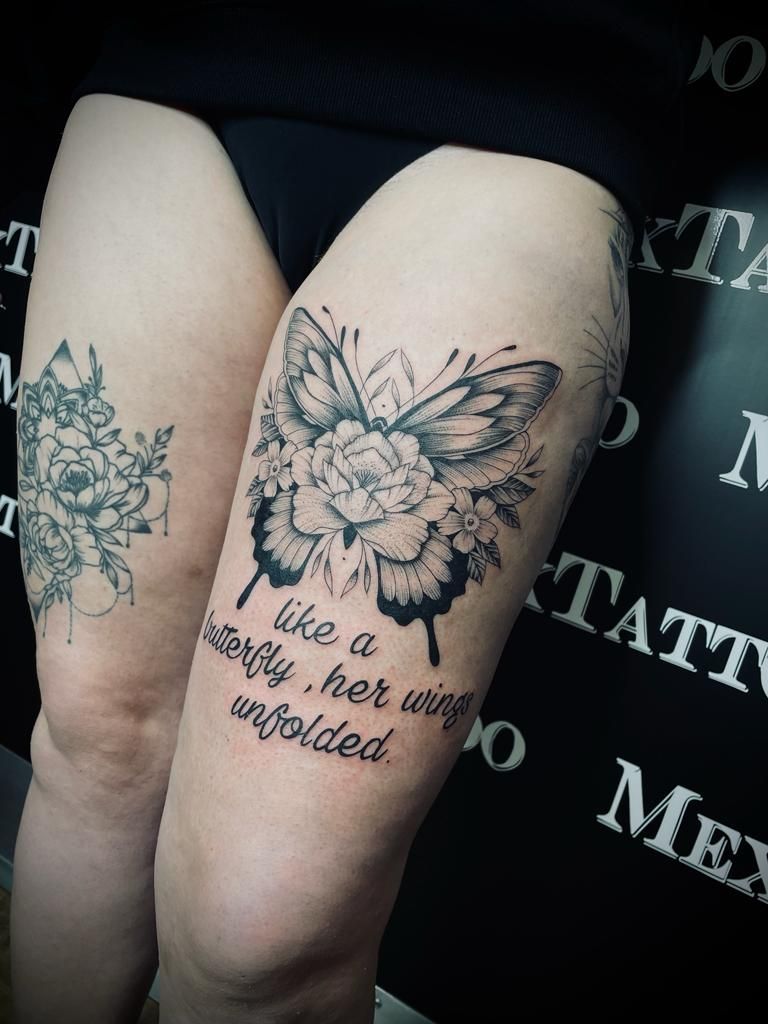 eine Frau mit zwei Tätowierungen auf ihrem Oberschenkel , eines Schmetterlings und eines Blumenstraußes .