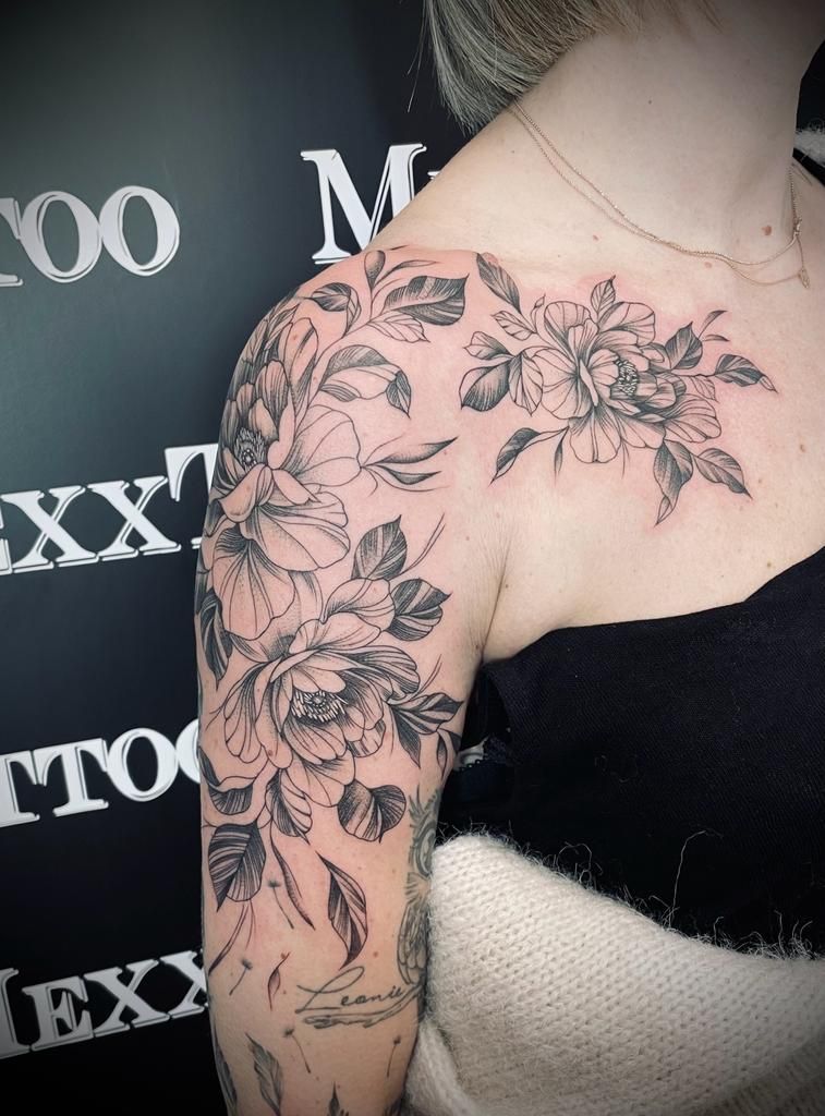 eine Frau mit einem Blumentattoo auf ihrer Schulter und Brust