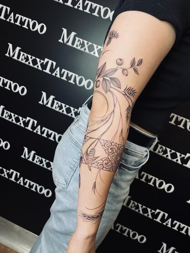 eine Frau mit einem Blumentattoo auf ihrem Arm