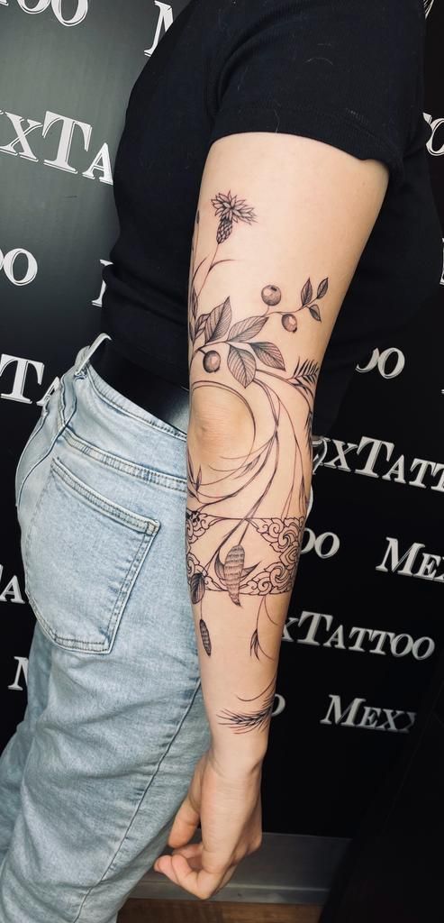 eine Frau mit einem Blumentattoo auf ihrem Arm .