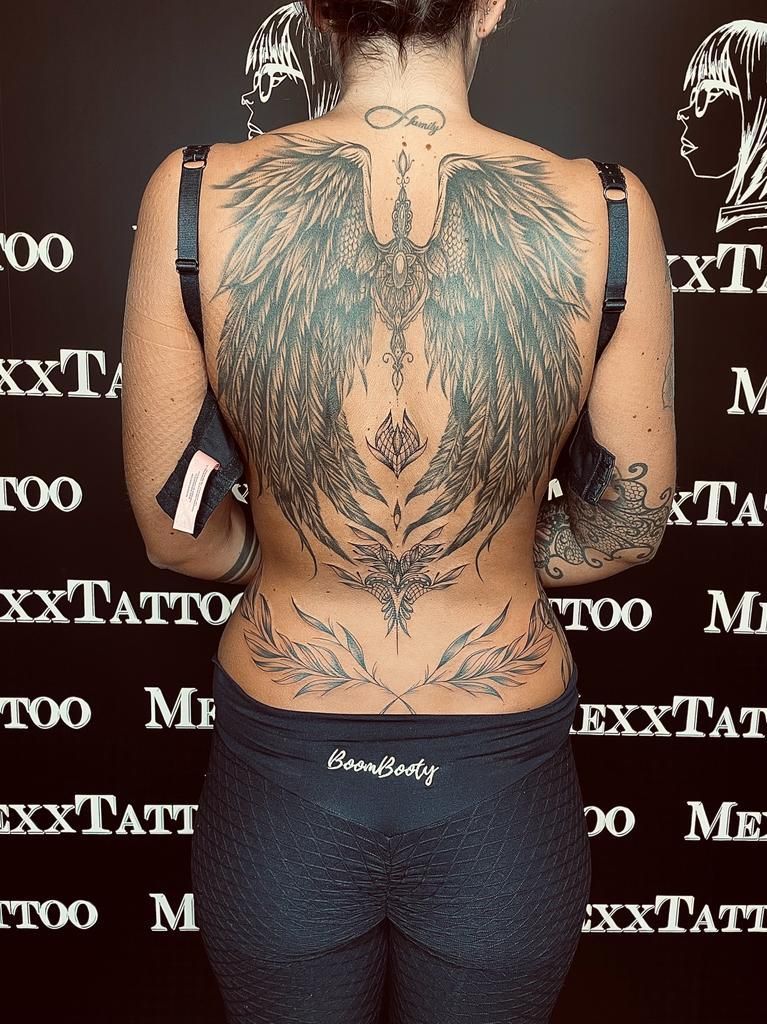 eine Frau mit vielen Tätowierungen auf ihrem Rücken