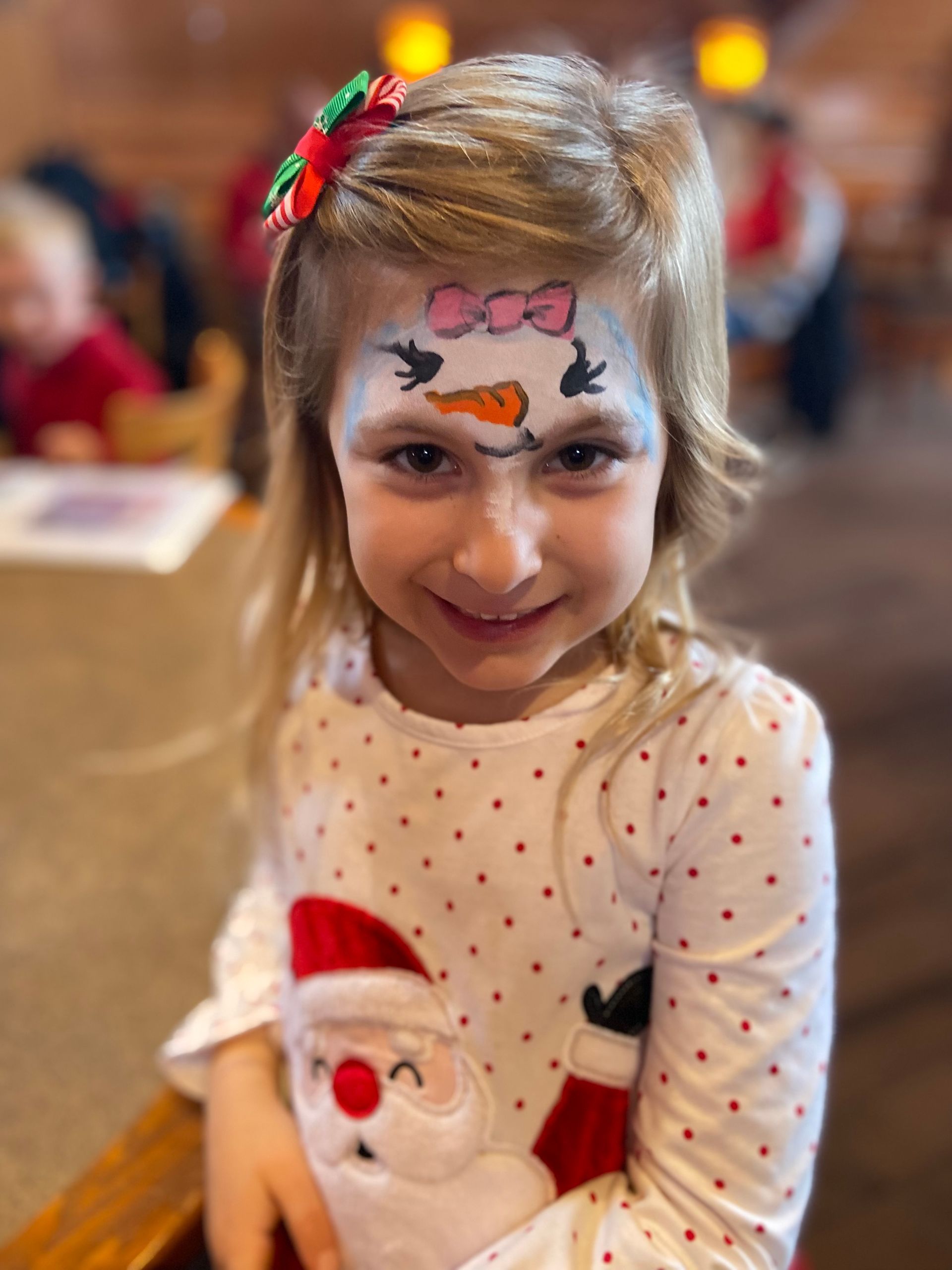 A little girl with a snowman painted on her face