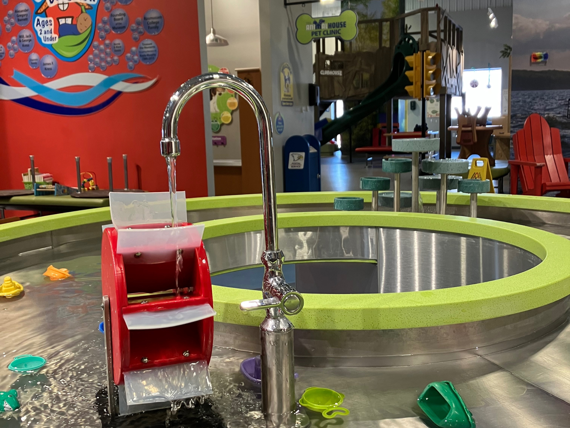 A water table with a faucet and toys in it.