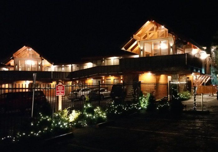 A large building is lit up at night with a no parking sign in front of it