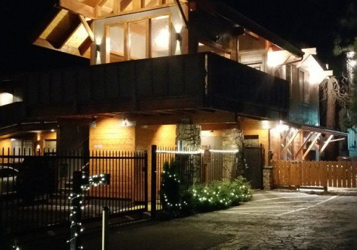 A large wooden house is lit up at night