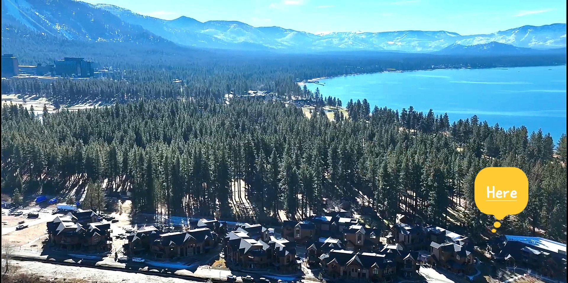 An aerial view of a lake surrounded by trees and mountains