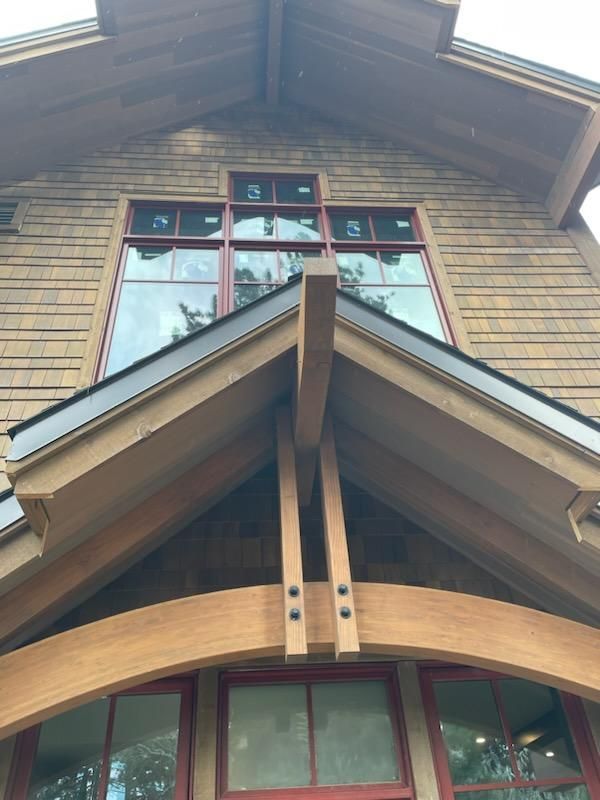 A house with a wooden roof and a red window