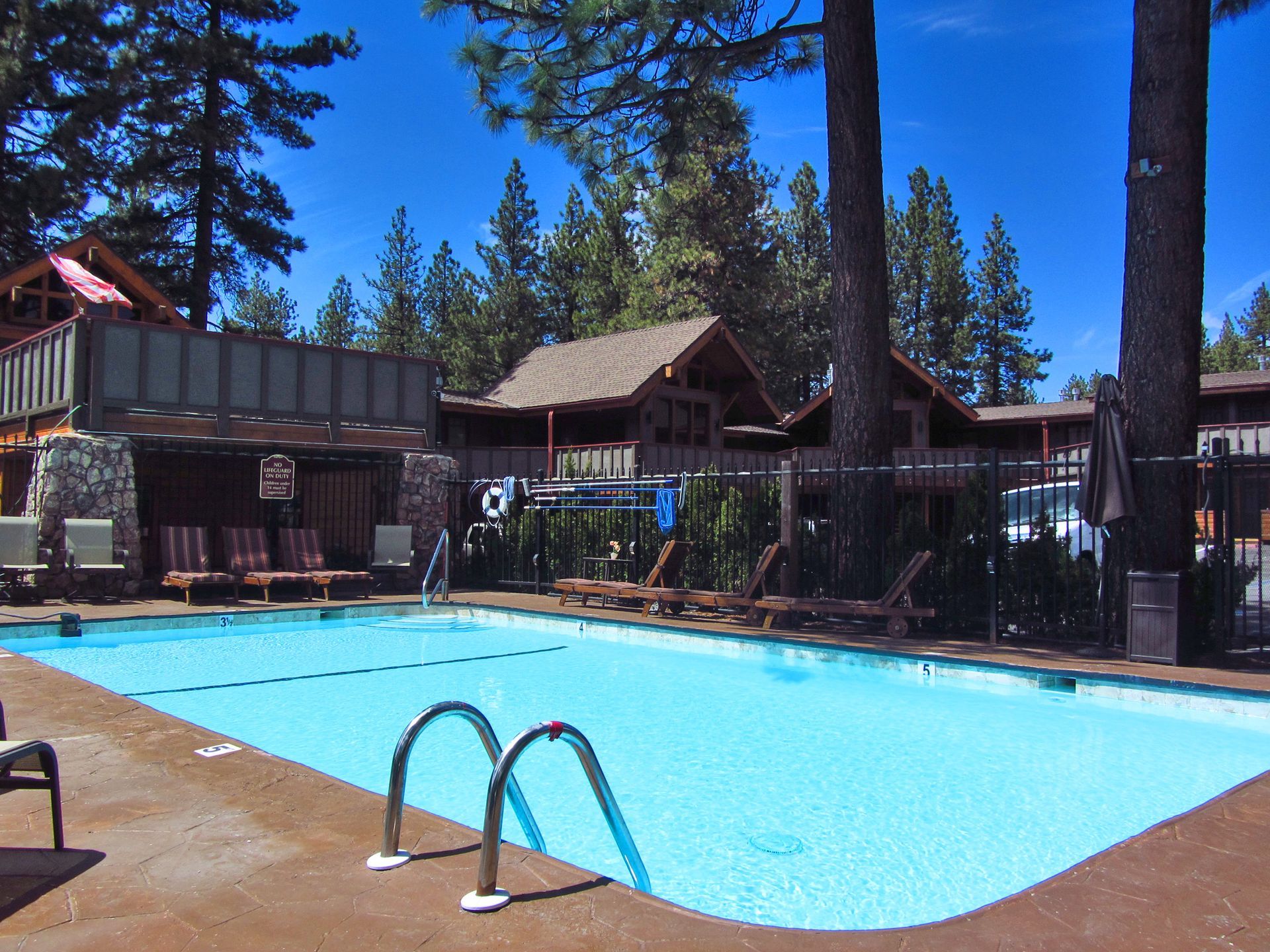 A large swimming pool surrounded by chairs and trees