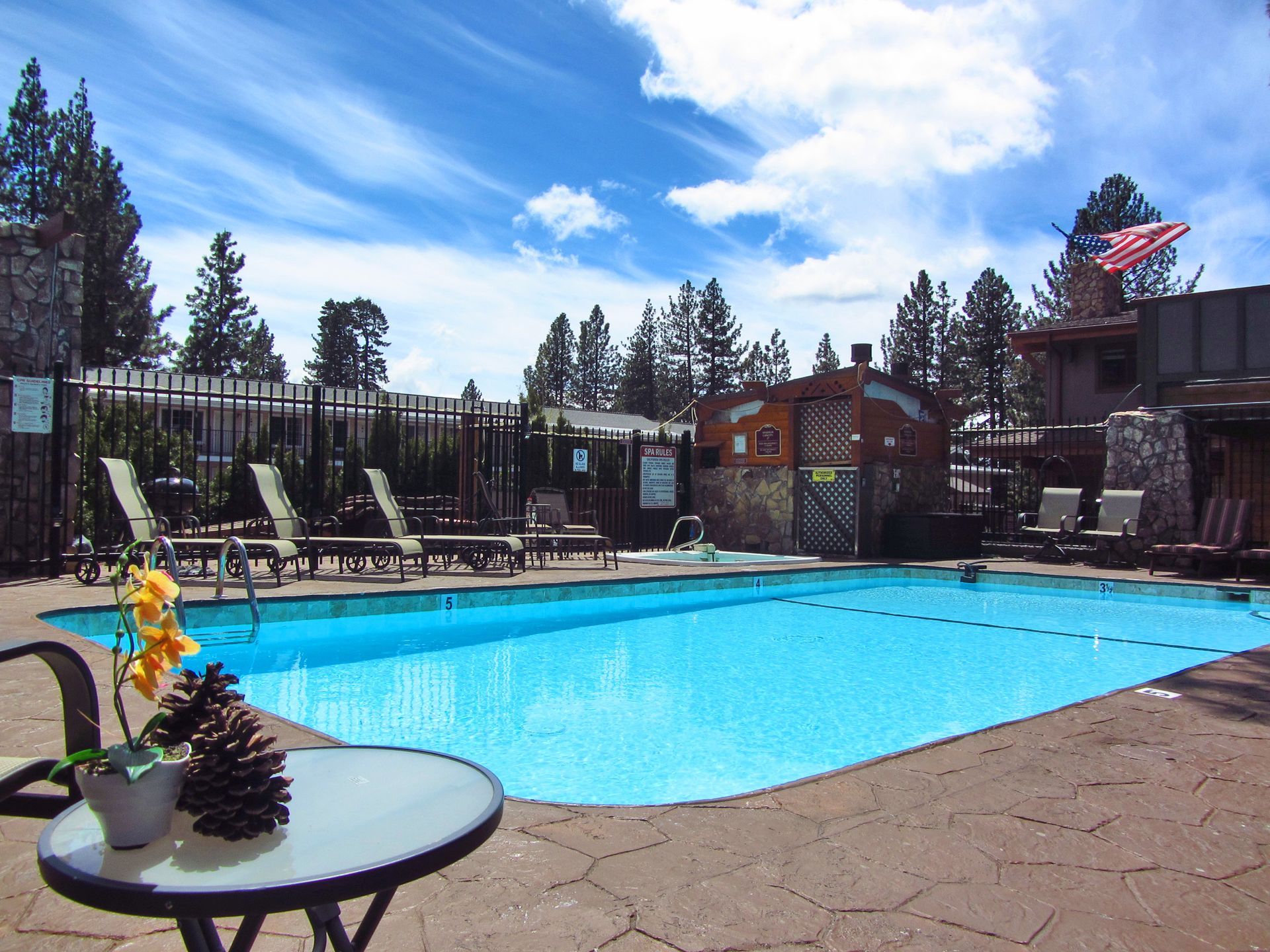 A large swimming pool with a table and chairs around it