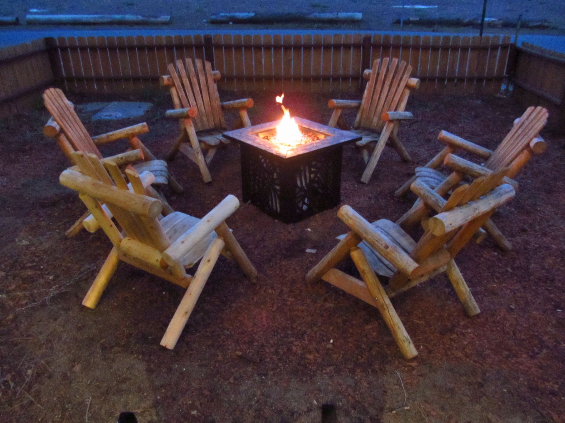 A group of chairs around a fire pit at night