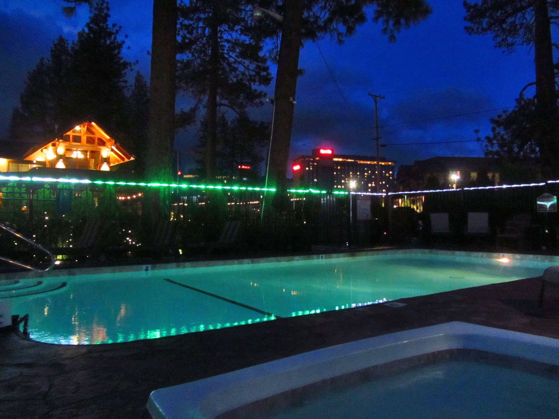 A large swimming pool is lit up at night