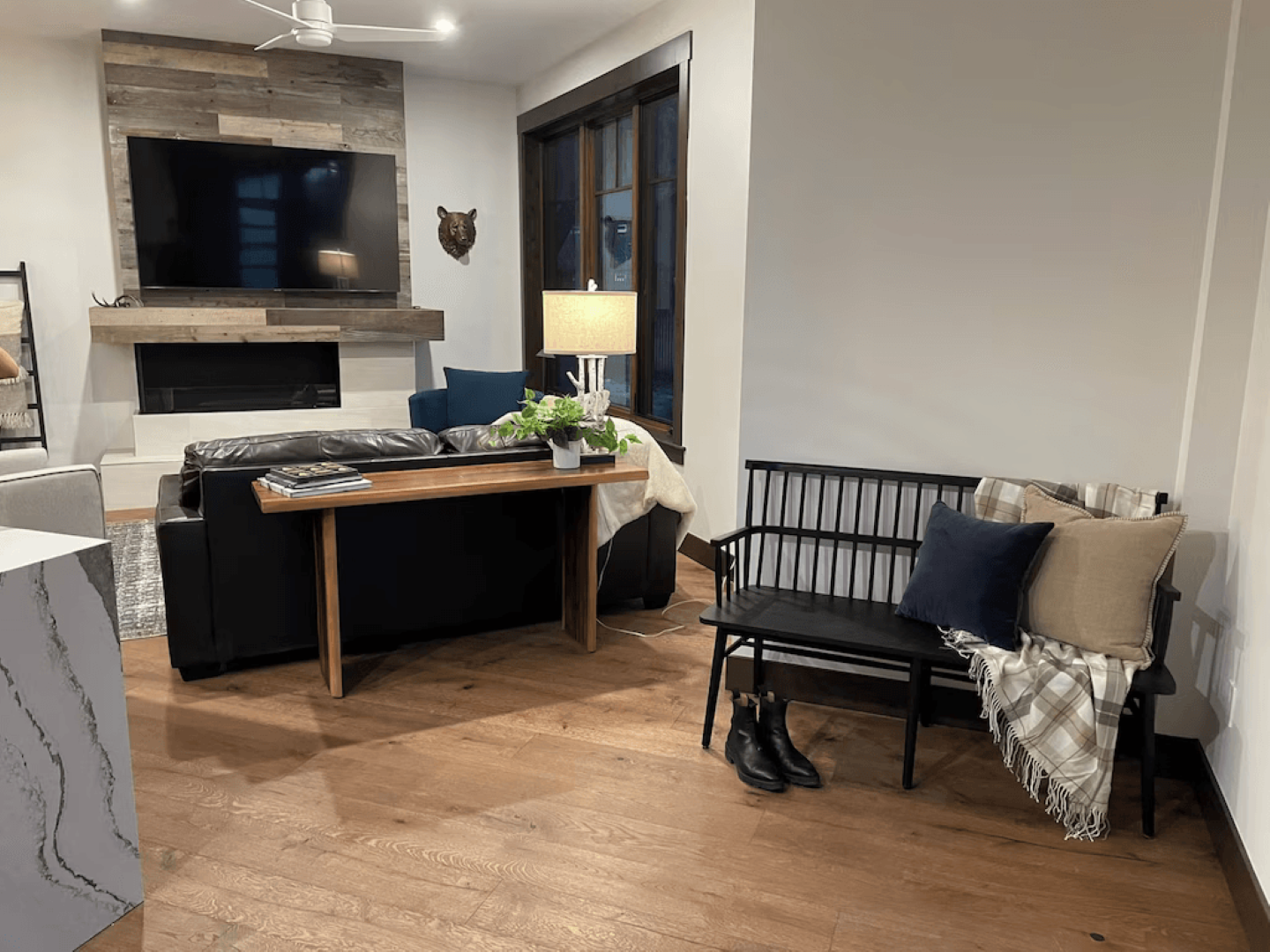 A living room with a couch , bench , table and television.