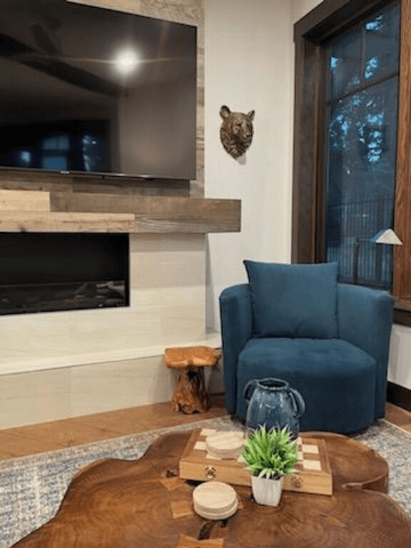 A living room with a blue chair and a large flat screen tv