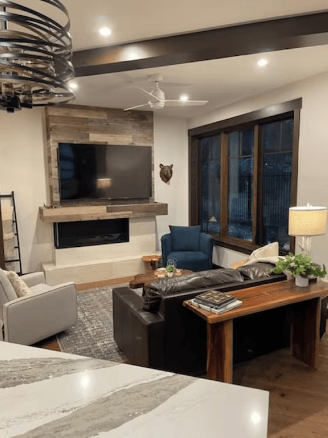 A living room with a couch , chairs , a television and a fireplace.