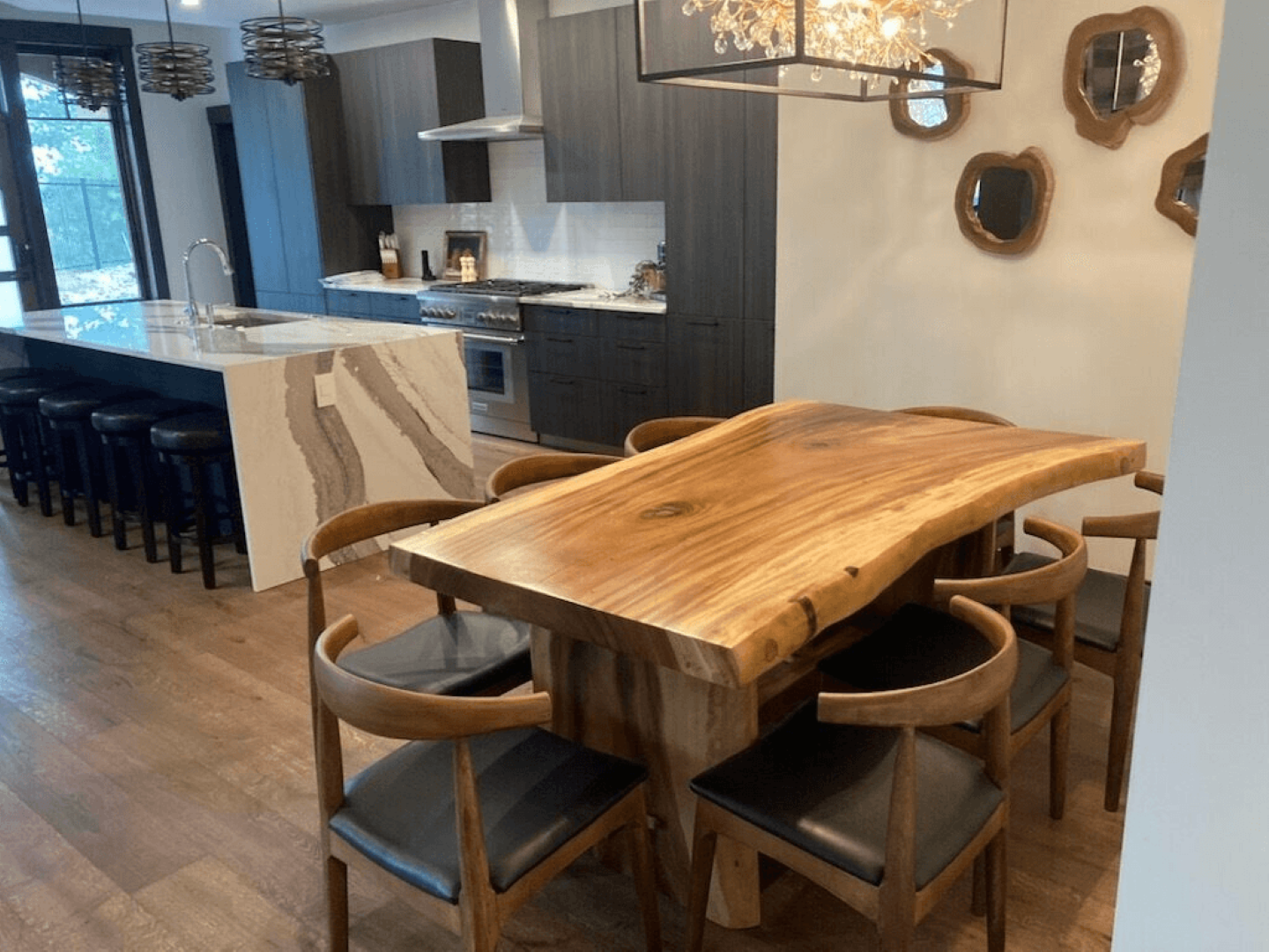 A wooden dining table with chairs in a kitchen.