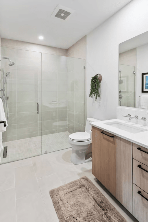 A bathroom with a toilet , sink , and walk in shower.