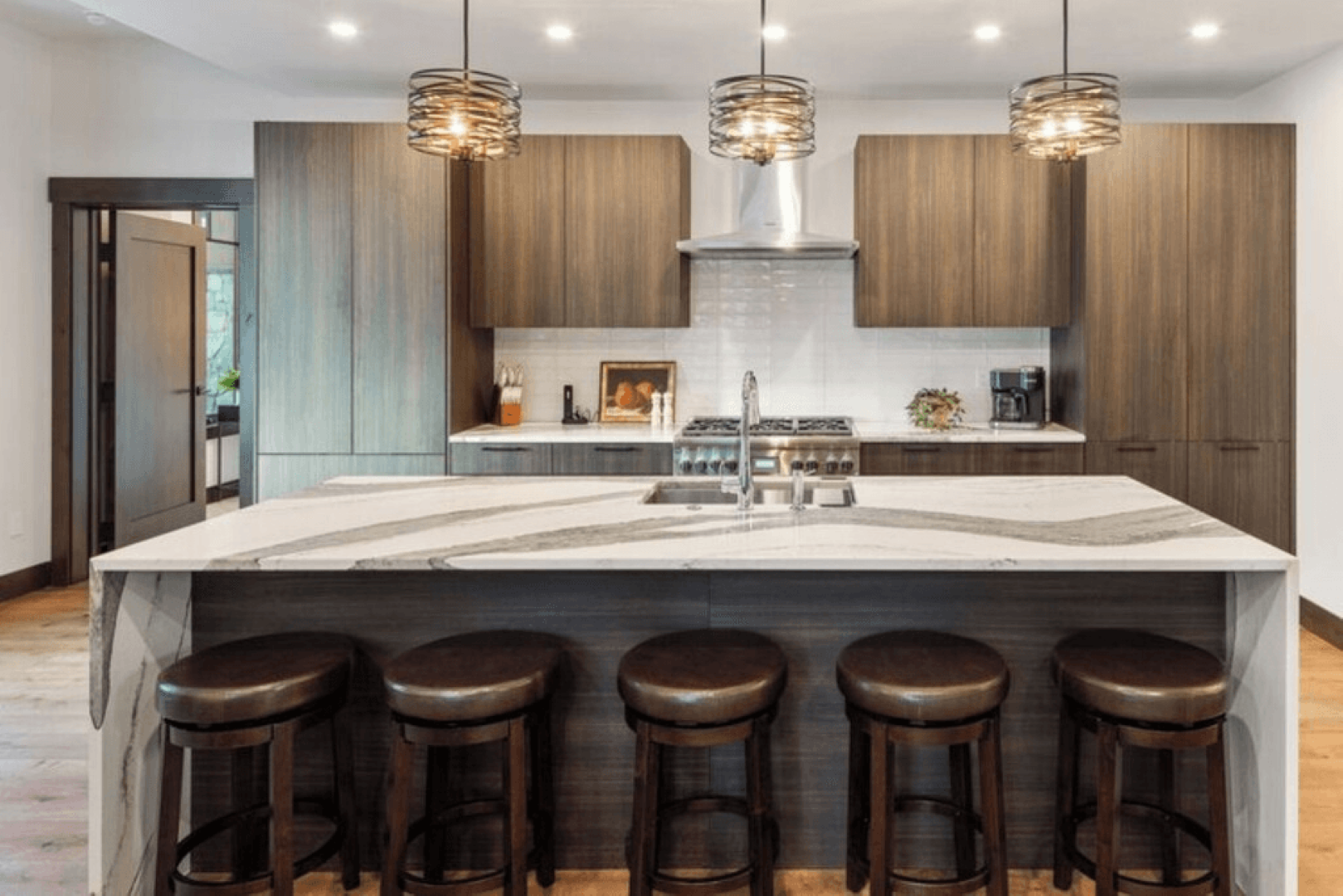 A kitchen with a large island and stools.