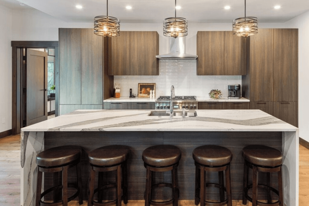 A kitchen with a large island and stools.