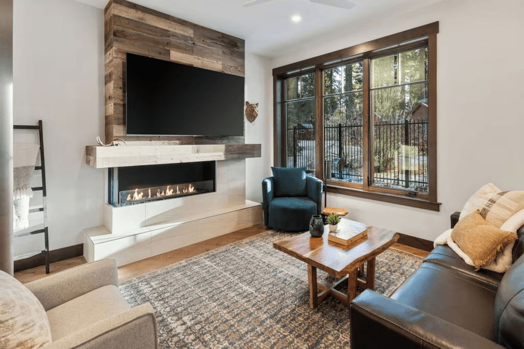 A living room with a couch , chair , coffee table and television.