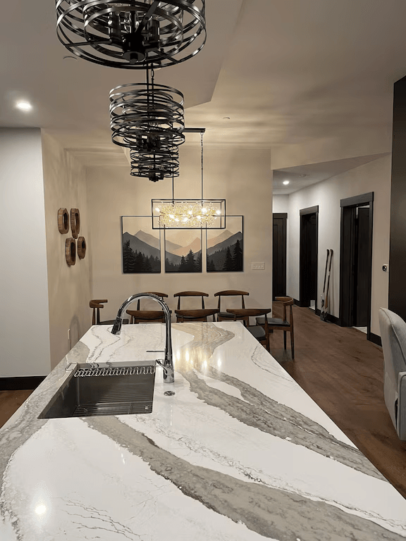 A kitchen with a sink and a chandelier hanging from the ceiling.