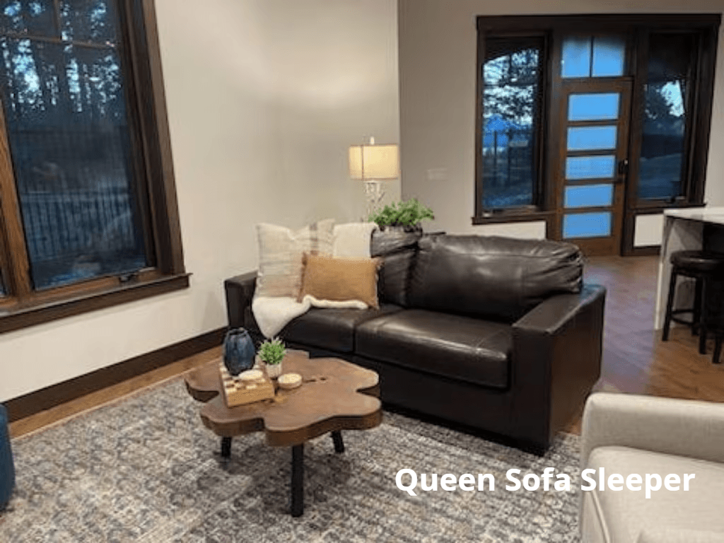 A living room with a brown leather couch and a wooden coffee table.