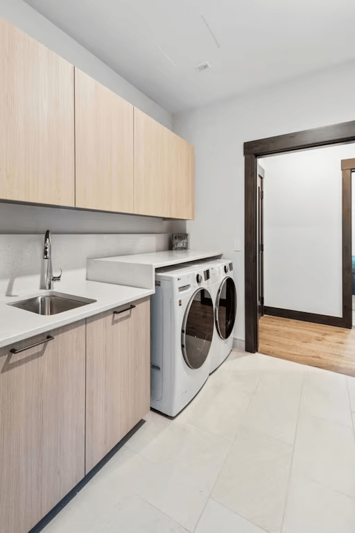 A laundry room with a washer and dryer and a sink