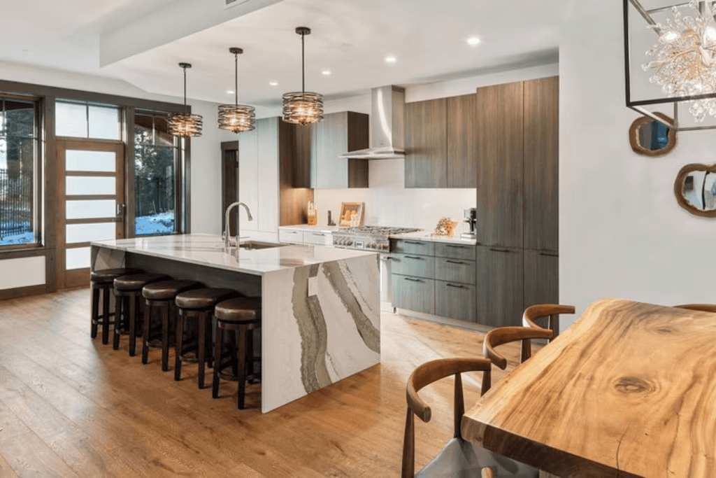 A kitchen with a large island and a wooden table.