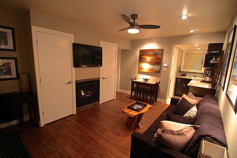A living room with a couch a fireplace and a ceiling fan
