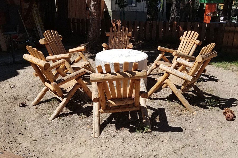 A group of wooden chairs sitting around a table in the sand