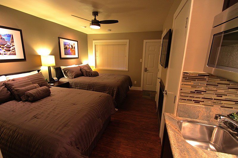 A room with two beds and a kitchen