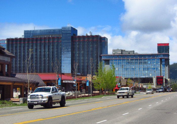 A truck is driving down a street in front of a large building.