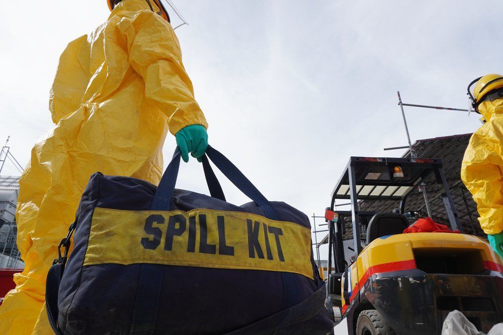 A Person in A Yellow Suit Is Carrying a Spill Kit Bag — NQ Parks and Gardens in Cairns, QLD