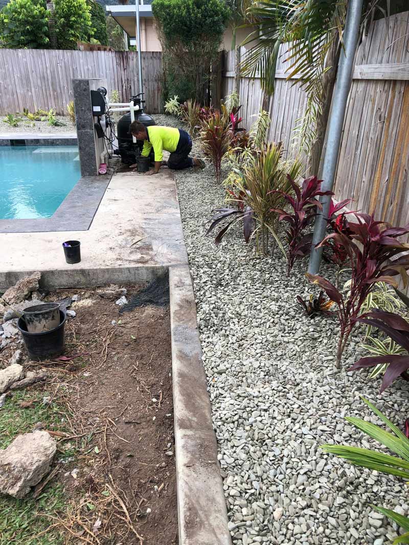 A Man Is Working in A Garden Next to A Pool — NQ Parks and Gardens in Innisfail, QLD