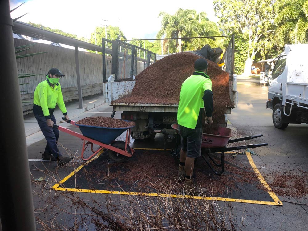 Two Men Unloading Mulch Into The Truck — NQ Parks and Gardens in Cairns, QLD