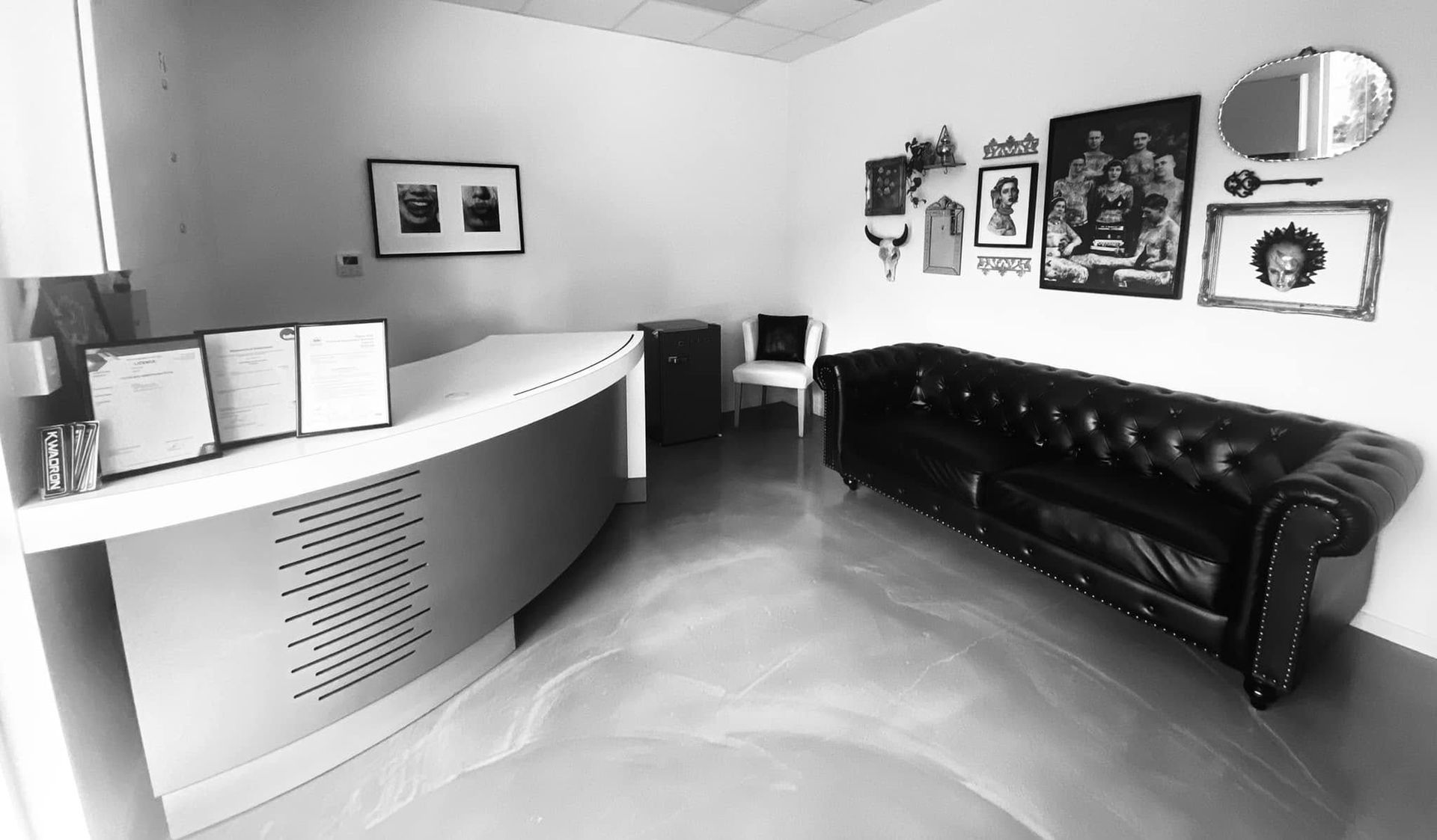 Black and White Photo of a Tattoo Parlor Reception Area With a Curved Counter — Pins and Needles Tattoo in Redlynch, QLD