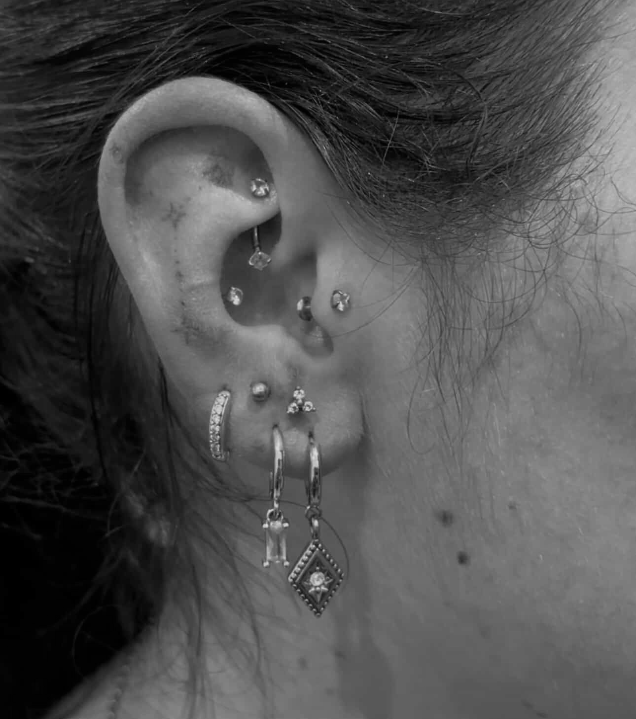 Woman's neck with a dragon tattoo near the ear. Black and white photo.