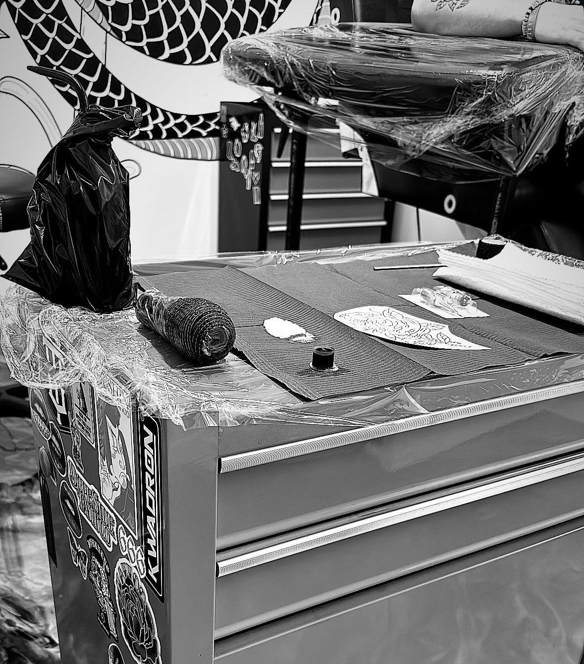 Woman's neck with a dragon tattoo near the ear. Black and white photo.