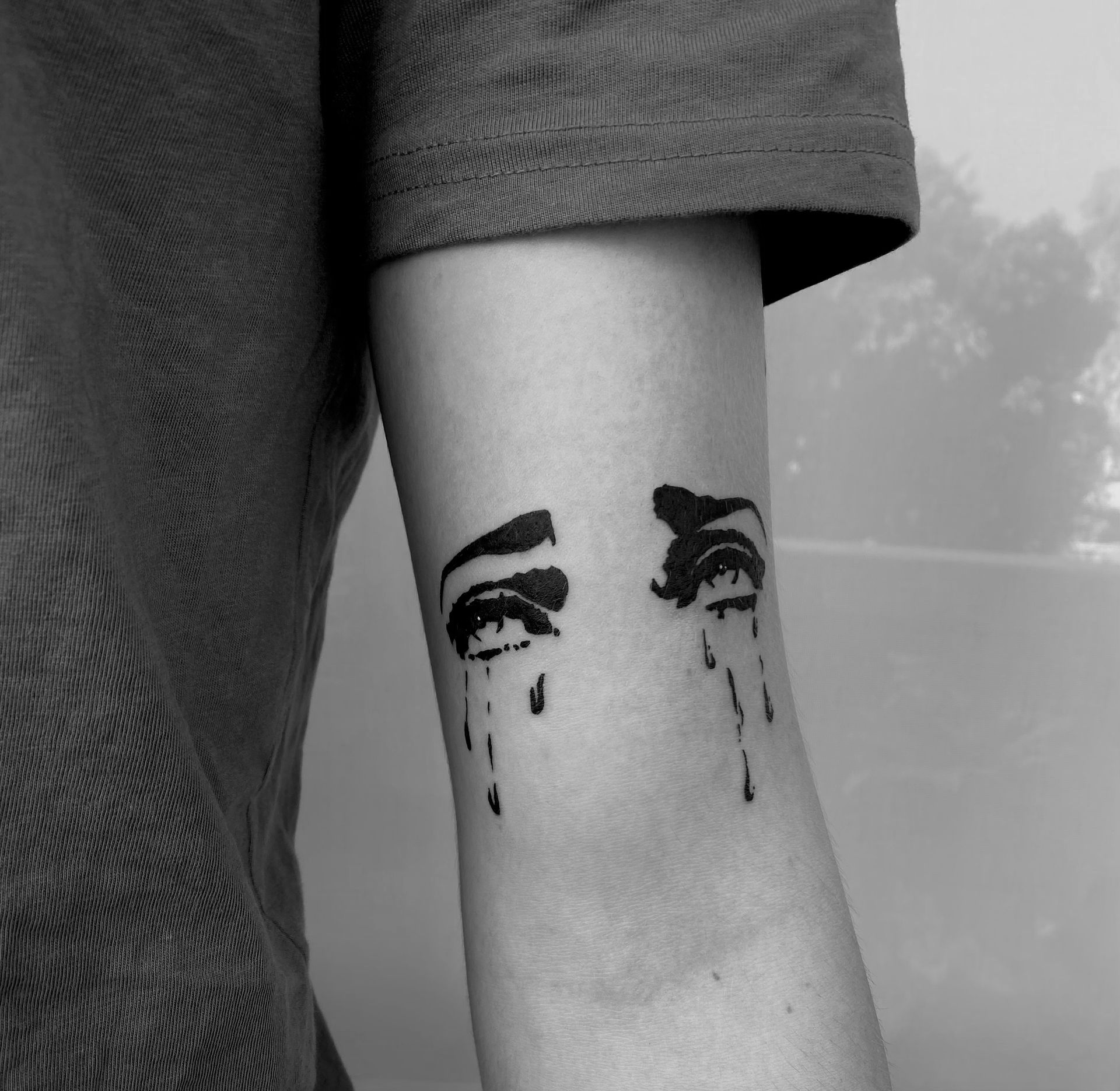 Tiger head tattoo on a person's thigh, roaring with open mouth, black and gray ink.