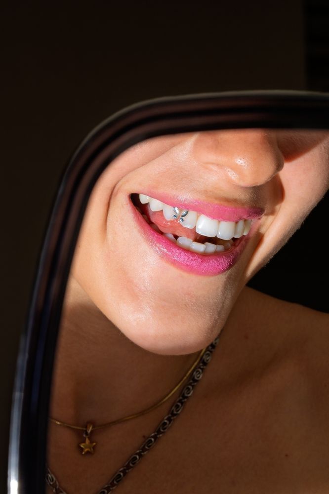 Woman's Smiling Mouth With Gem on Teeth — Pins and Needles Tattoo in Cairns, QLD