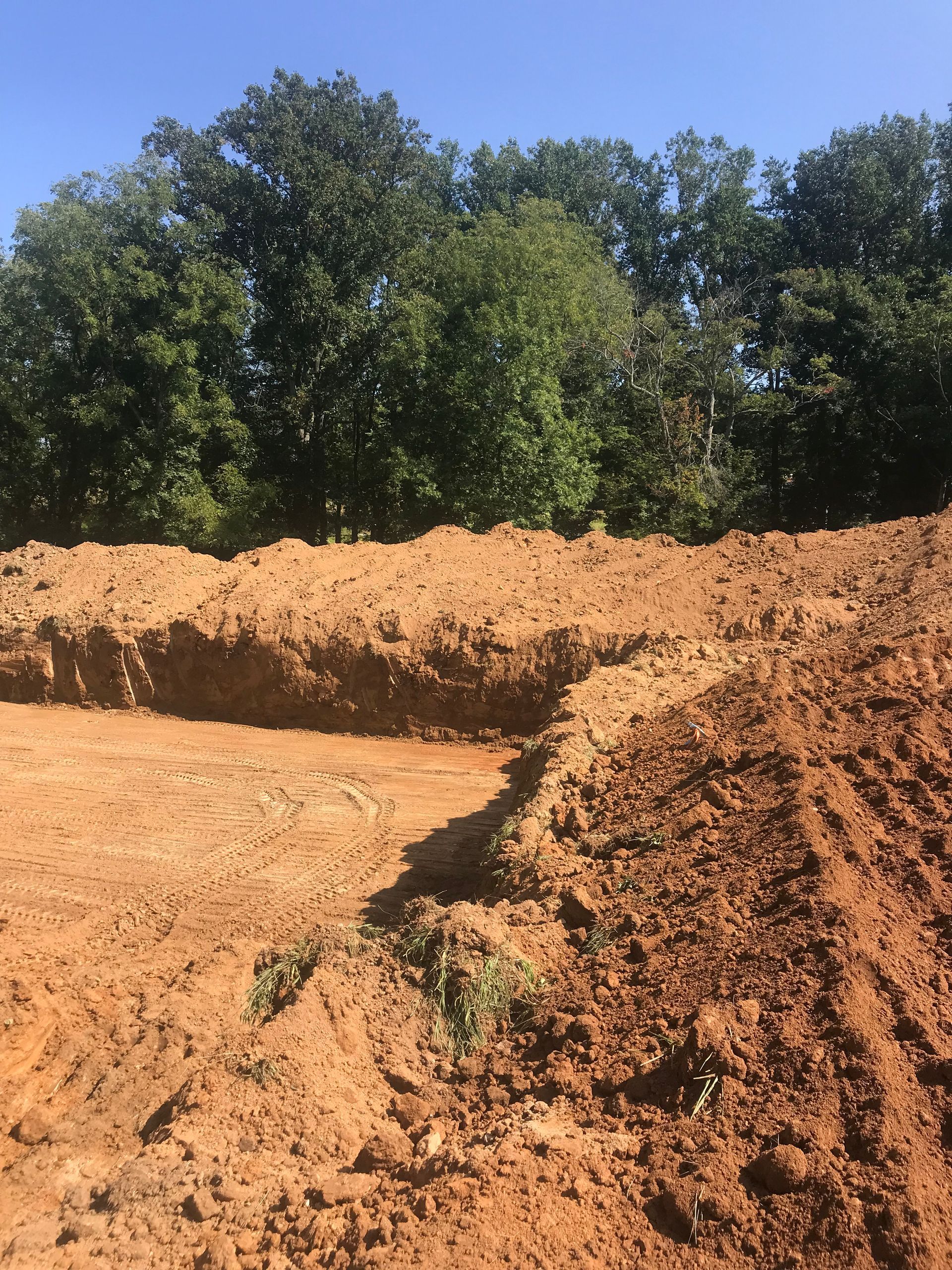 A pile of dirt with trees in the background